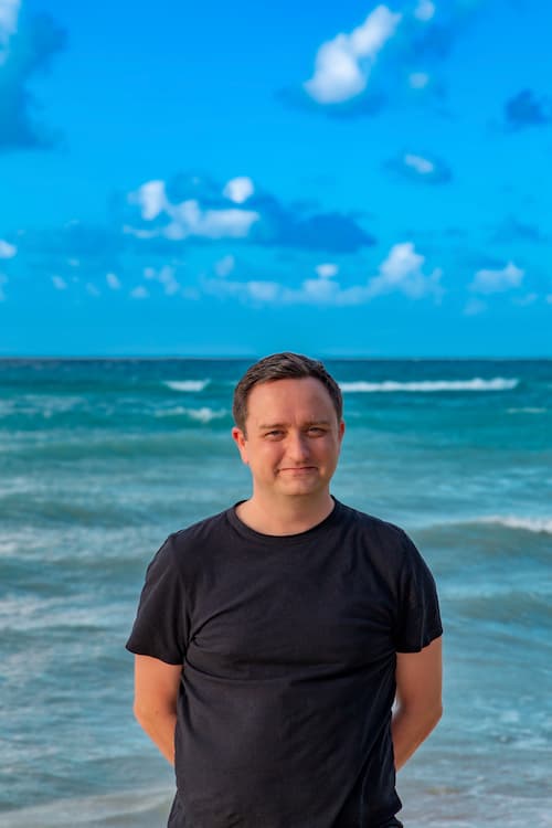 Brandon Caruana standing in the ocean in Cayman.